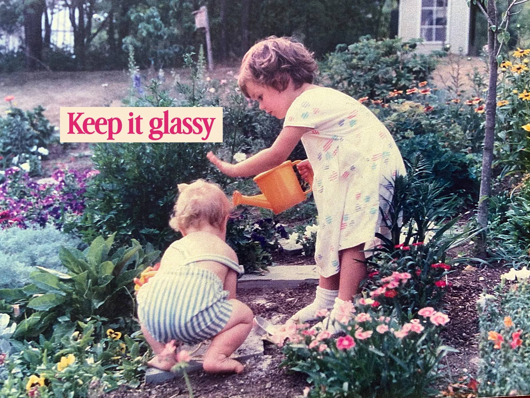 A child watering flowers in a sunny garden